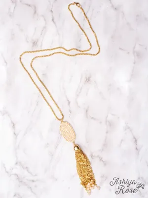 A LITTLE SPARKLE WHITE CRYSTAL OVAL PENDANT TASSEL ON A GOLD NECKLACE